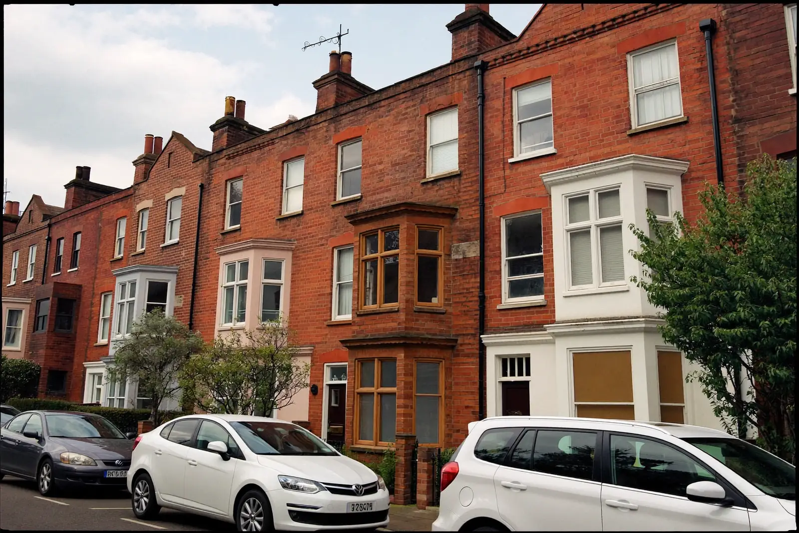 A UK terraced street with a mix of older and newly replaced windows